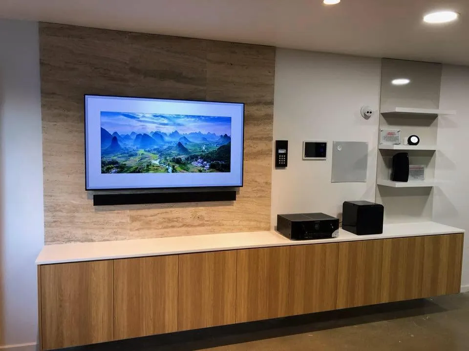 Floating entertainment unit with a stone feature wall, built by Js Cabinetry
