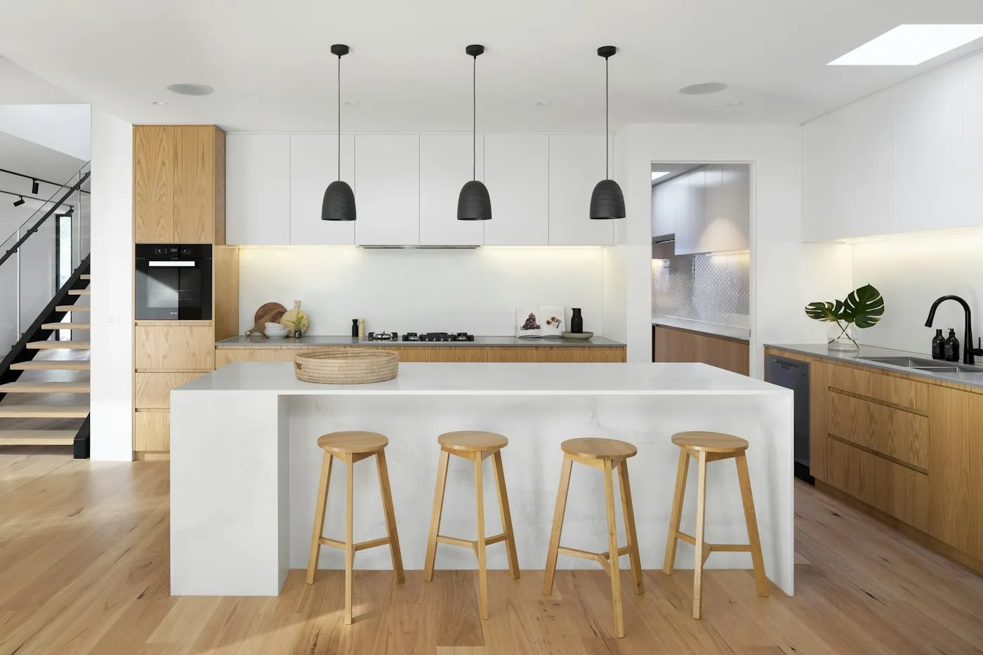 Warm timber kitchen with a white island benchtop and oak cabinetry
