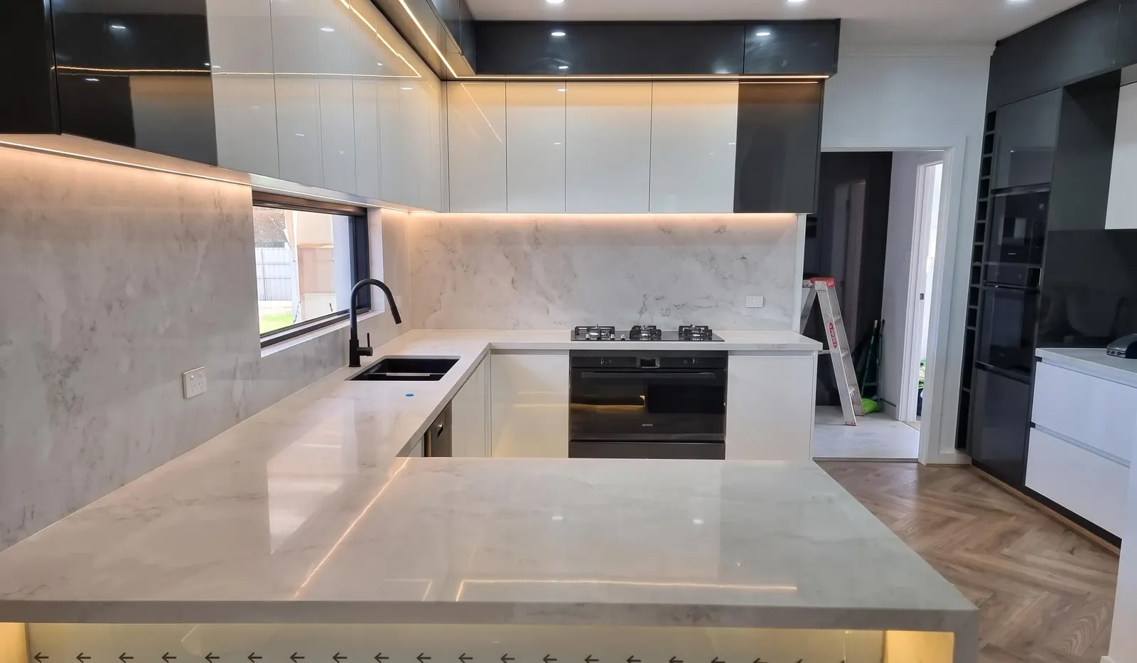 Large U-shape stone kitchen with warm LED lighting